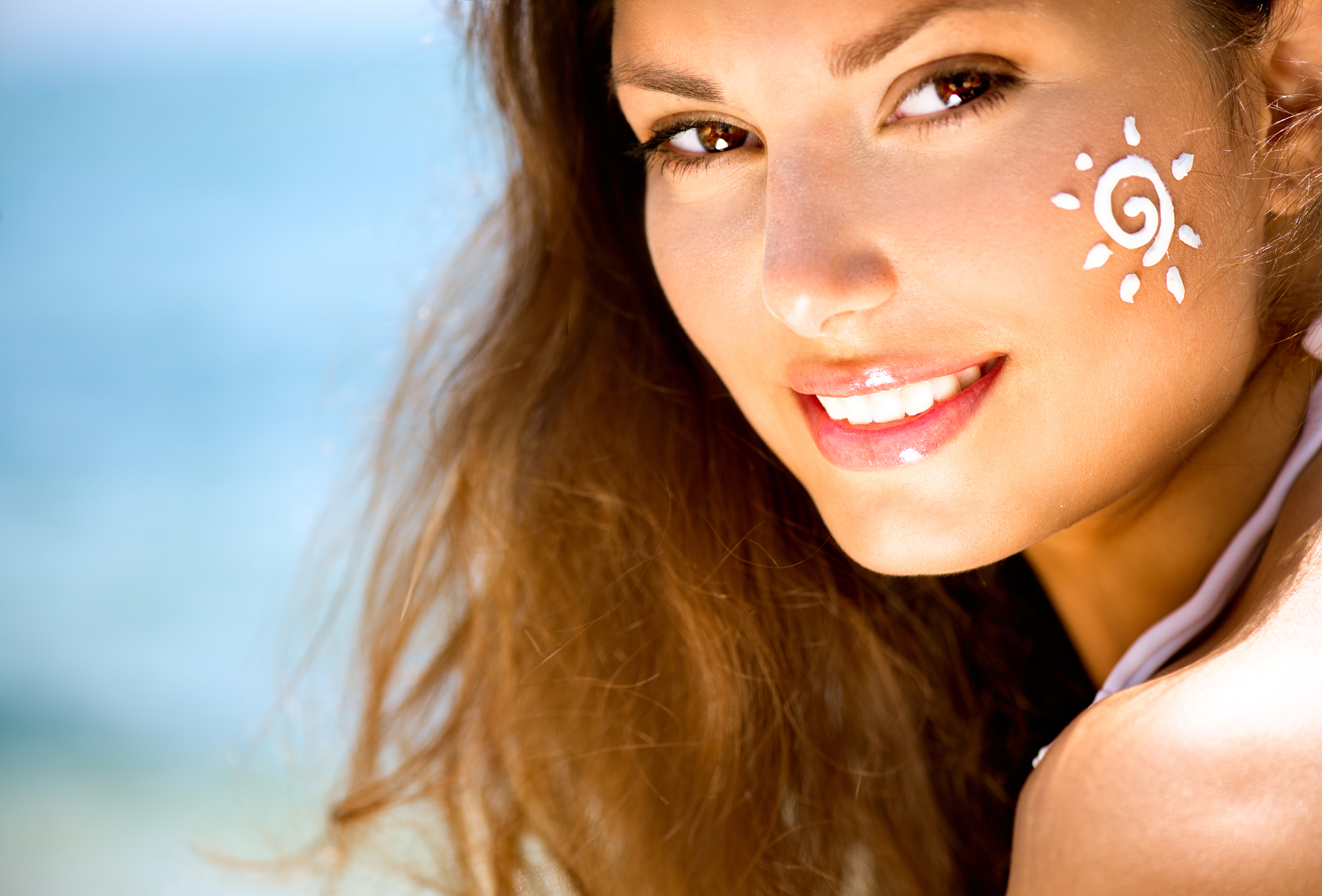 Beauty Girl Applying Sun Tan Cream on her Face. Sun Tanning